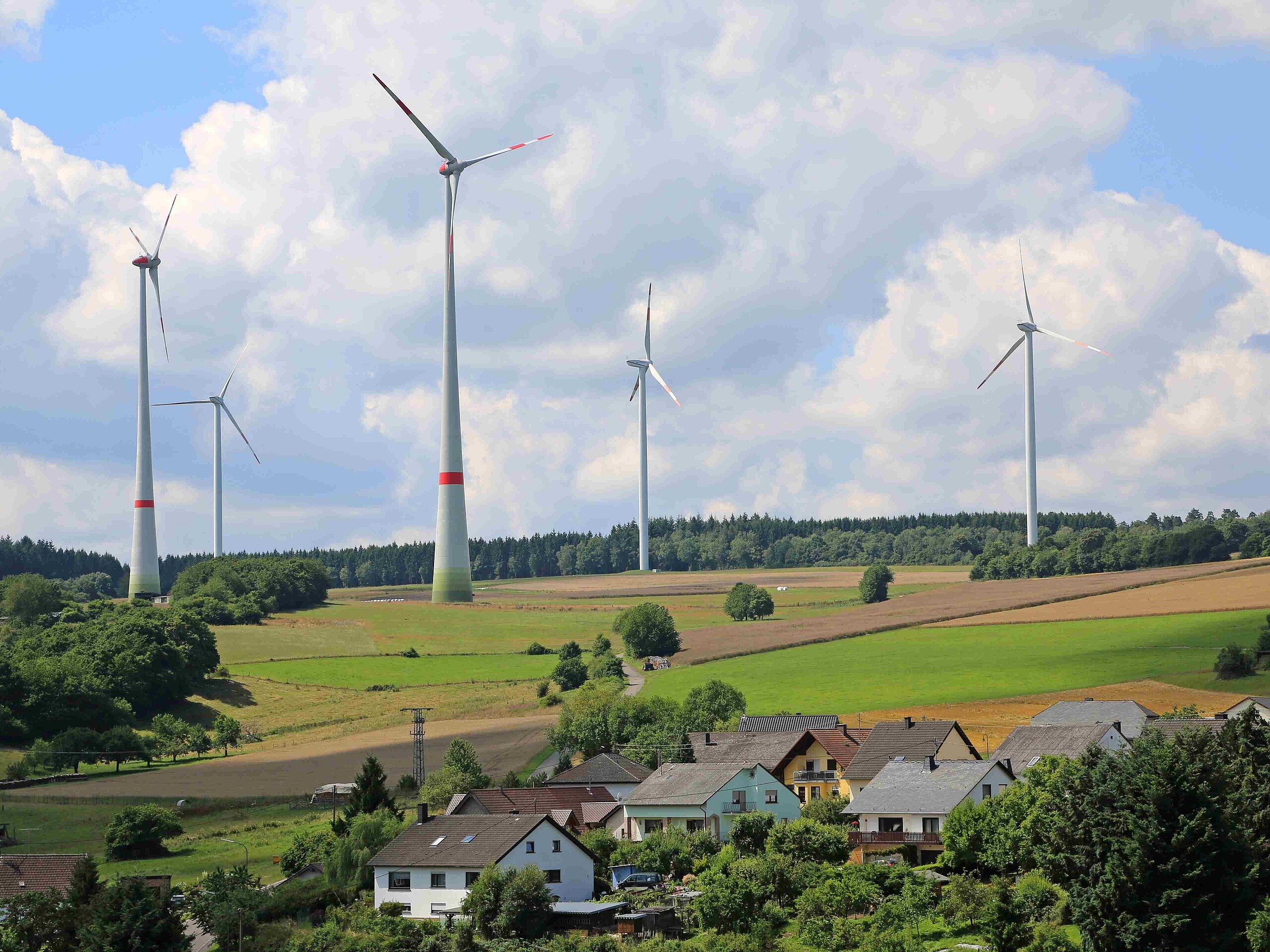 Windräder vor Dorf