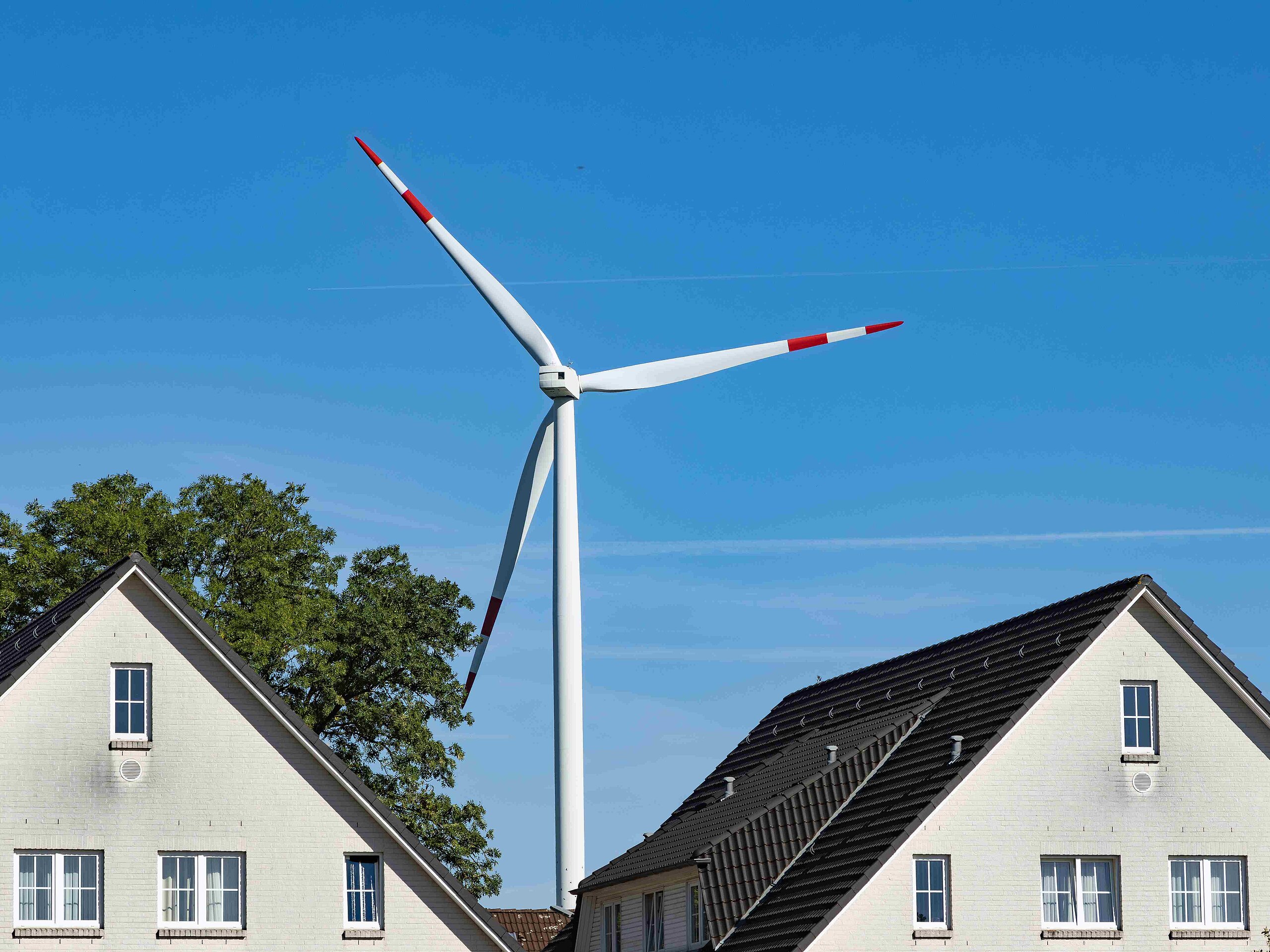 Windrad vor Häuserdach