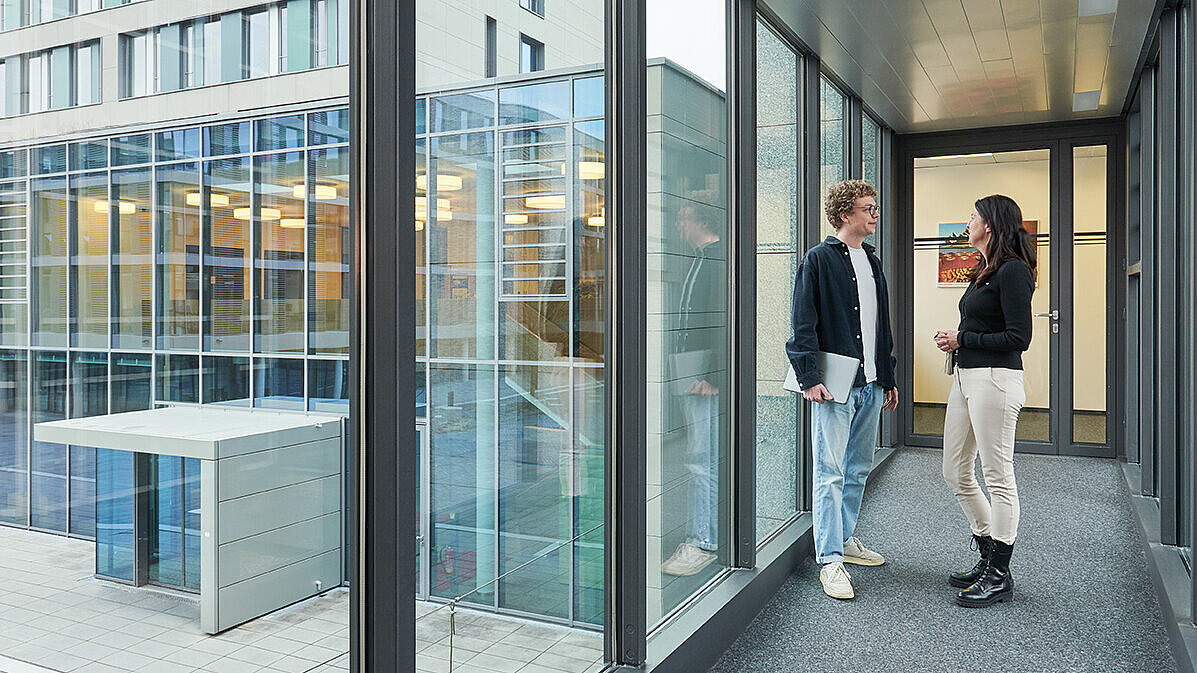 Mitarbeitende unterhalten sich im Gebäude
