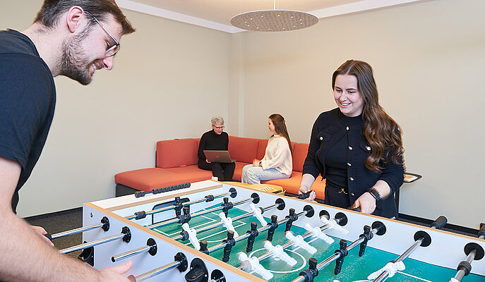 Mitarbeitende spielen Tischfußball