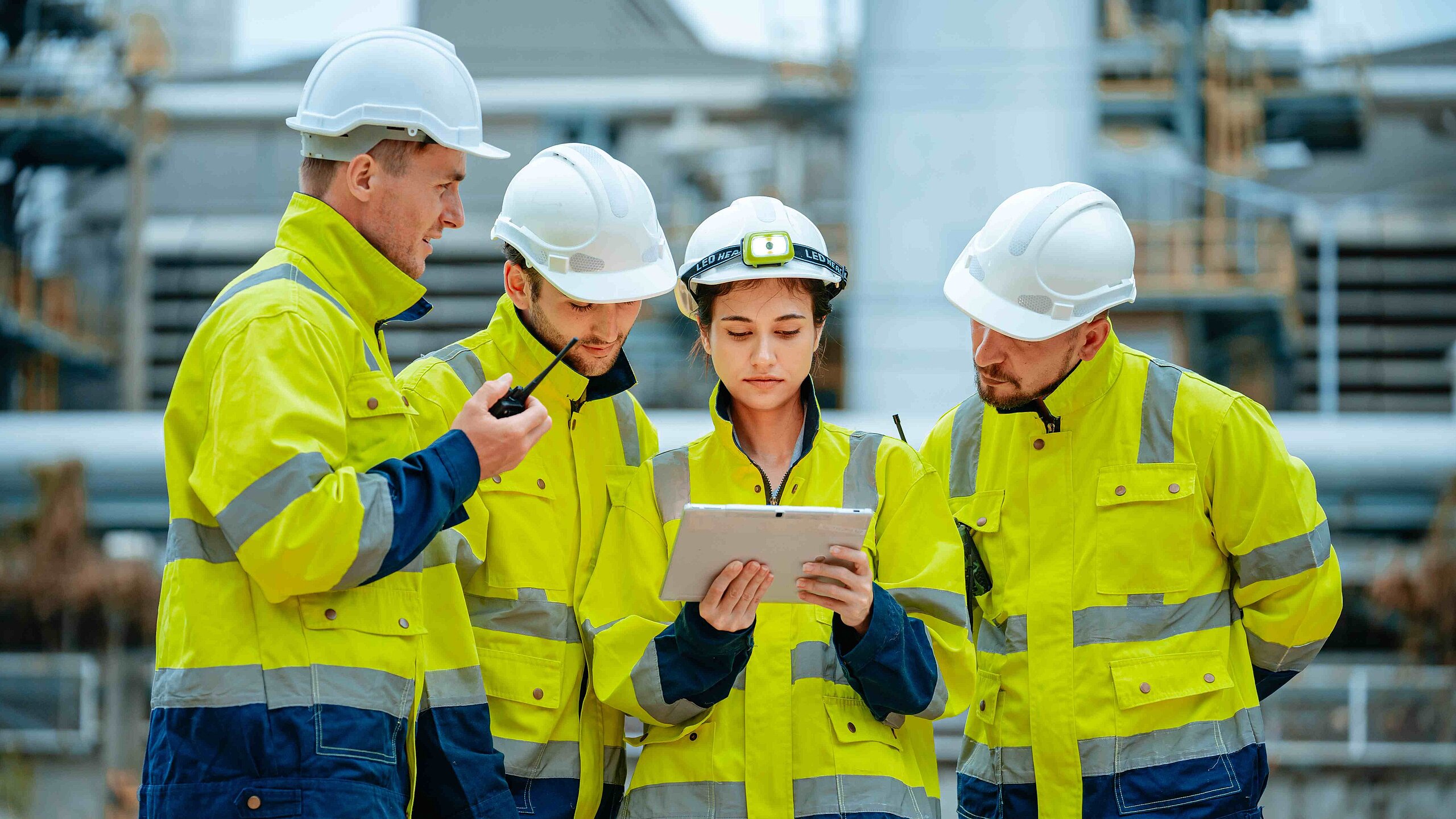 Ingenieure beraten sich und schauen auf ein Tablet.