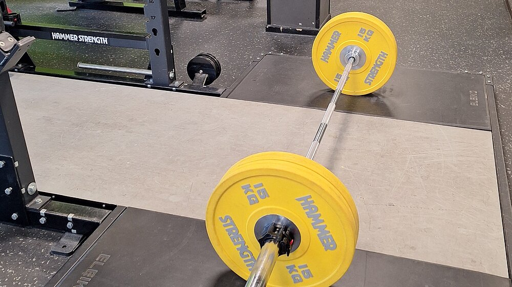 Gelbe Langhanteln in Fitnessstudio